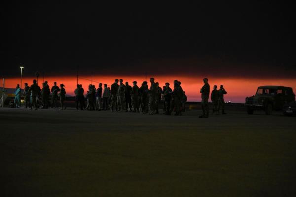 Army perso<em></em>nnel stand at a port as smoke rises over the sky in Alexandroupolis in the northeastern Evros region, Greece